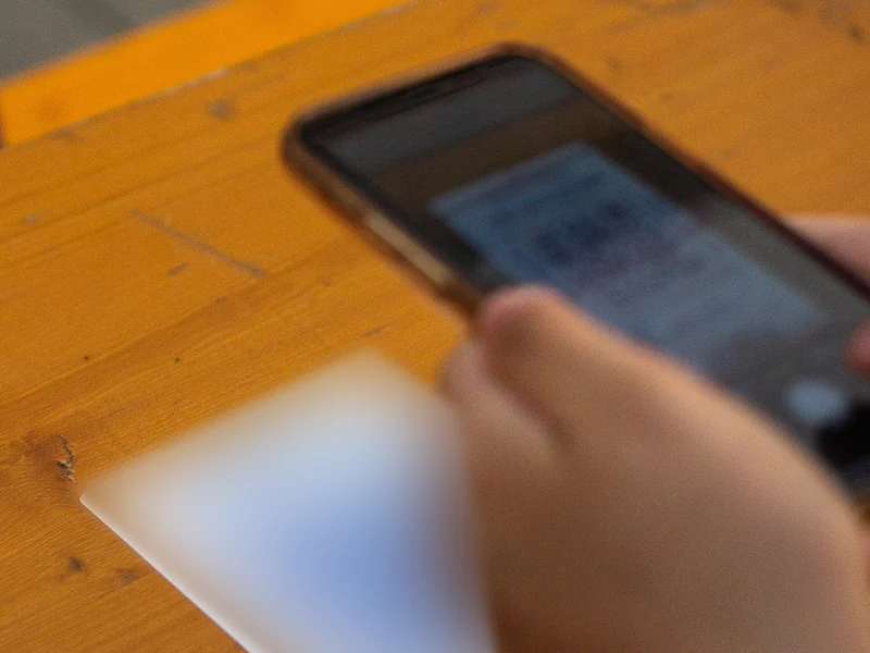 Ein Gast scannt den QR-Code auf der Tischkarte mit dem Handy