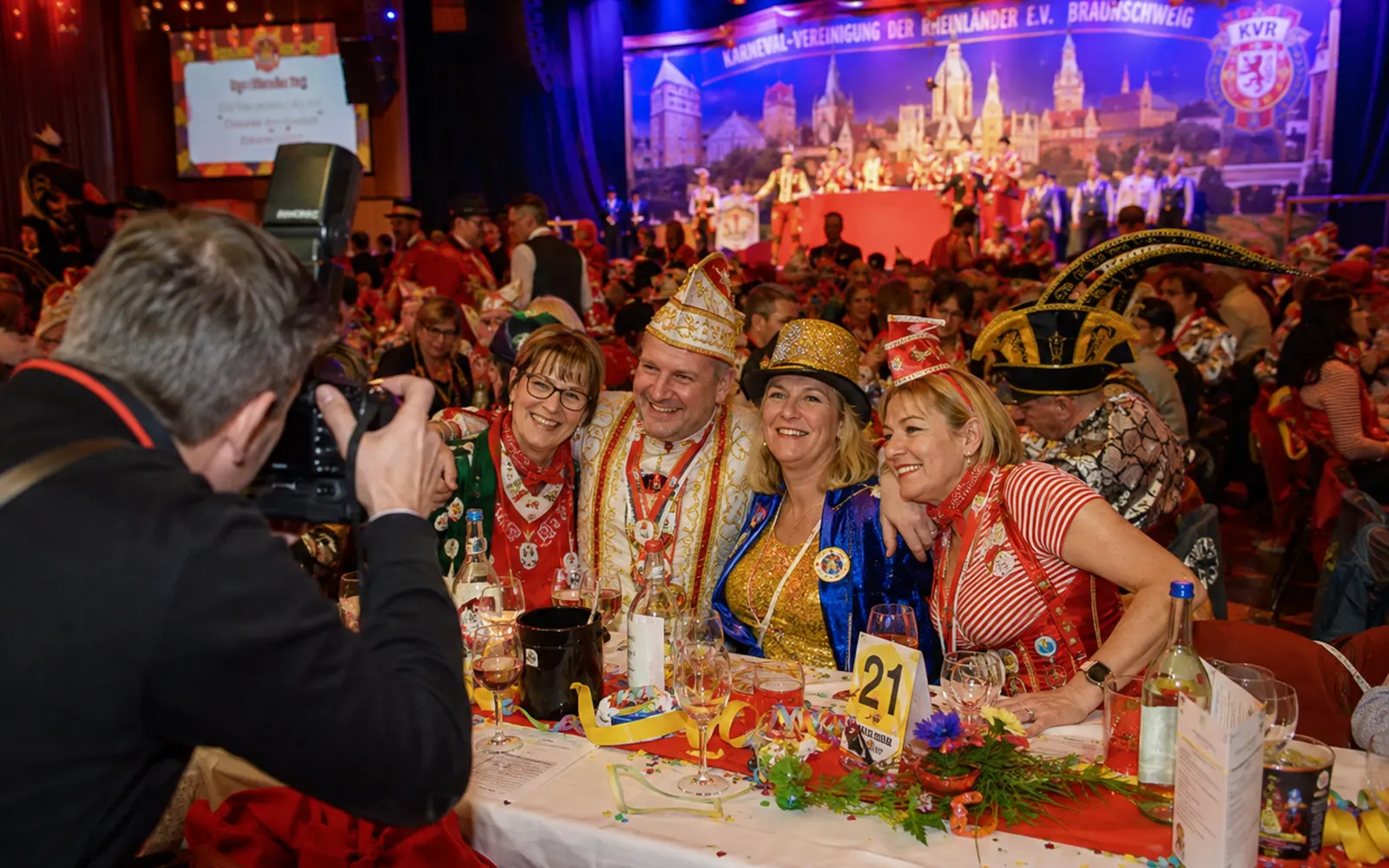 Gruppe in Kostümen posiert bei einer Karnevalssitzung für ein Foto