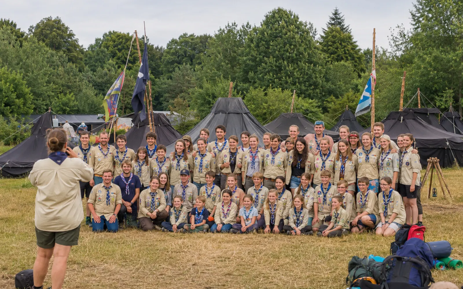 Pfadfindergruppe stellt sich im Zeltlager für ein Gruppenfoto auf